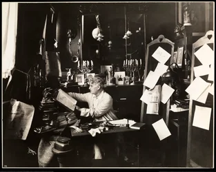 David Belasco i sitt arbetsrum, bläddrar i en ordbok, 1909 (silvergelatintryck)